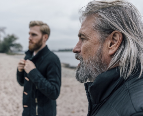 En gammel mann og en ung mann på en strand